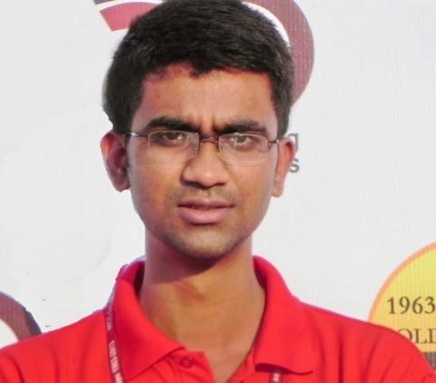 headshot of Ishtiyaque from the shoulders up, wearing a red polo and reading glasses, smiling